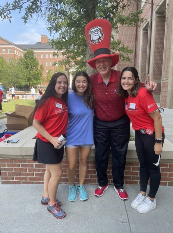 Dean Bill McDonaldp posing with students outside of the Tate Student Center.